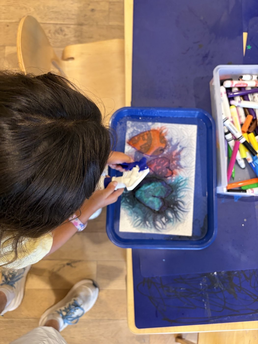 Art studio with easels, supplies, and child artwork on display